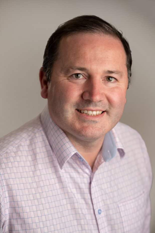 A smiling man in a collared shirt.
