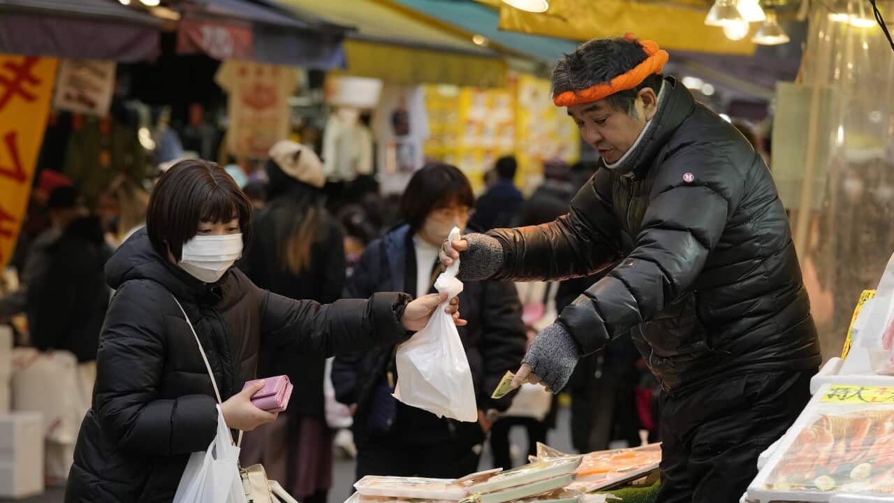 A woman purchasing food at a Tokyo food market