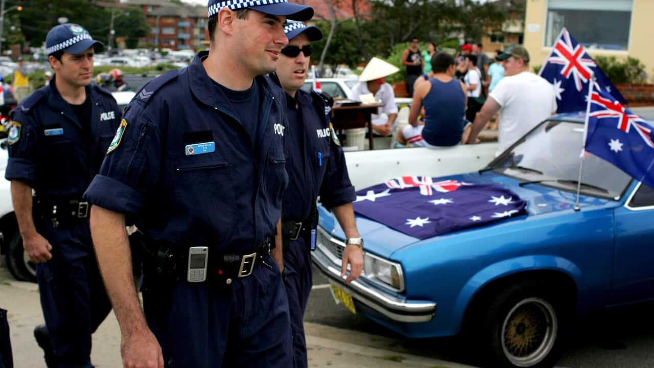 Police patrol where large pro-Australia groups gathered at Cronulla Beach in Sydney, Sunday, Dec. 11, 2005. (AAP Image/Paul Miller) NO ARCHIVING
