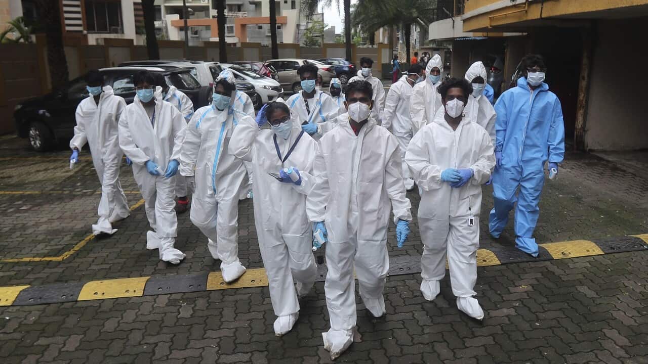 Health workers arrives to screen people for COVID-19 symptoms at a residential building in Mumbai, India, Sunday, July 26, 2020. India is the third hardest-hit country by the pandemic in the world after the United States and Brazil. (AP Photo/Rafiq Maqboo