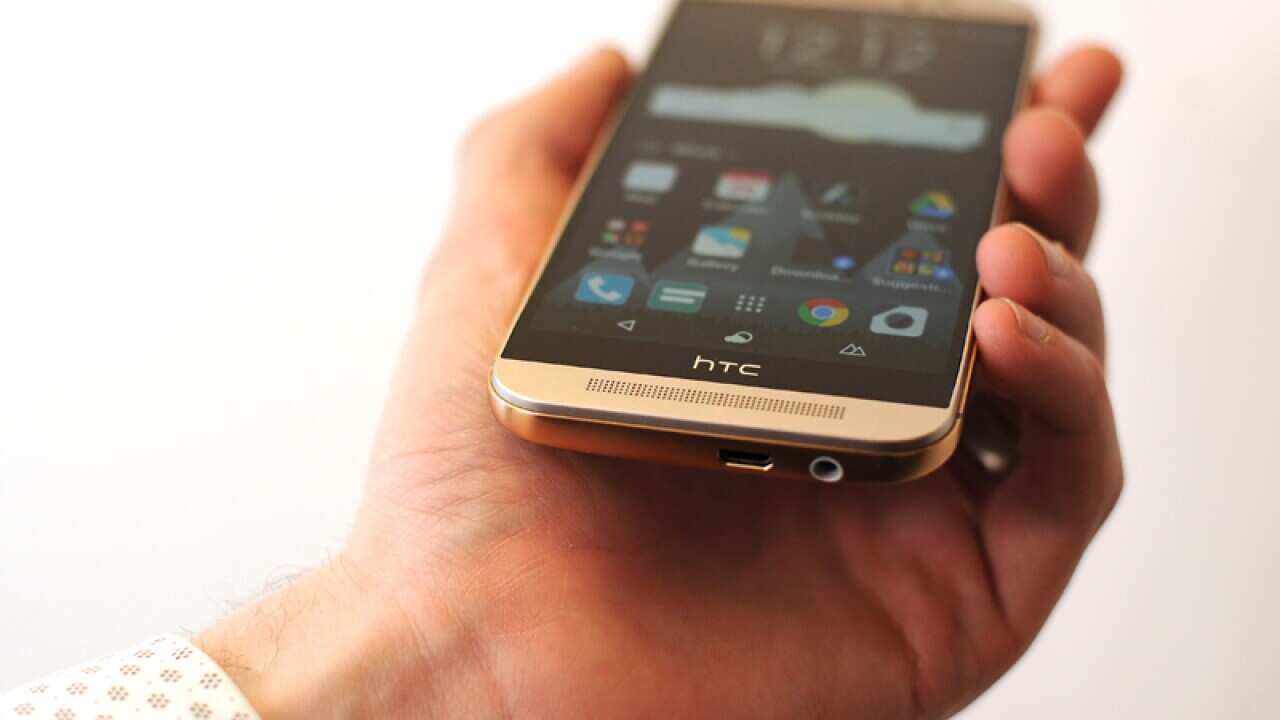 A man holds a HTC smartphone