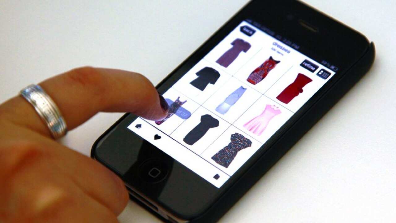 A woman browses an online clothing store on her iPhone