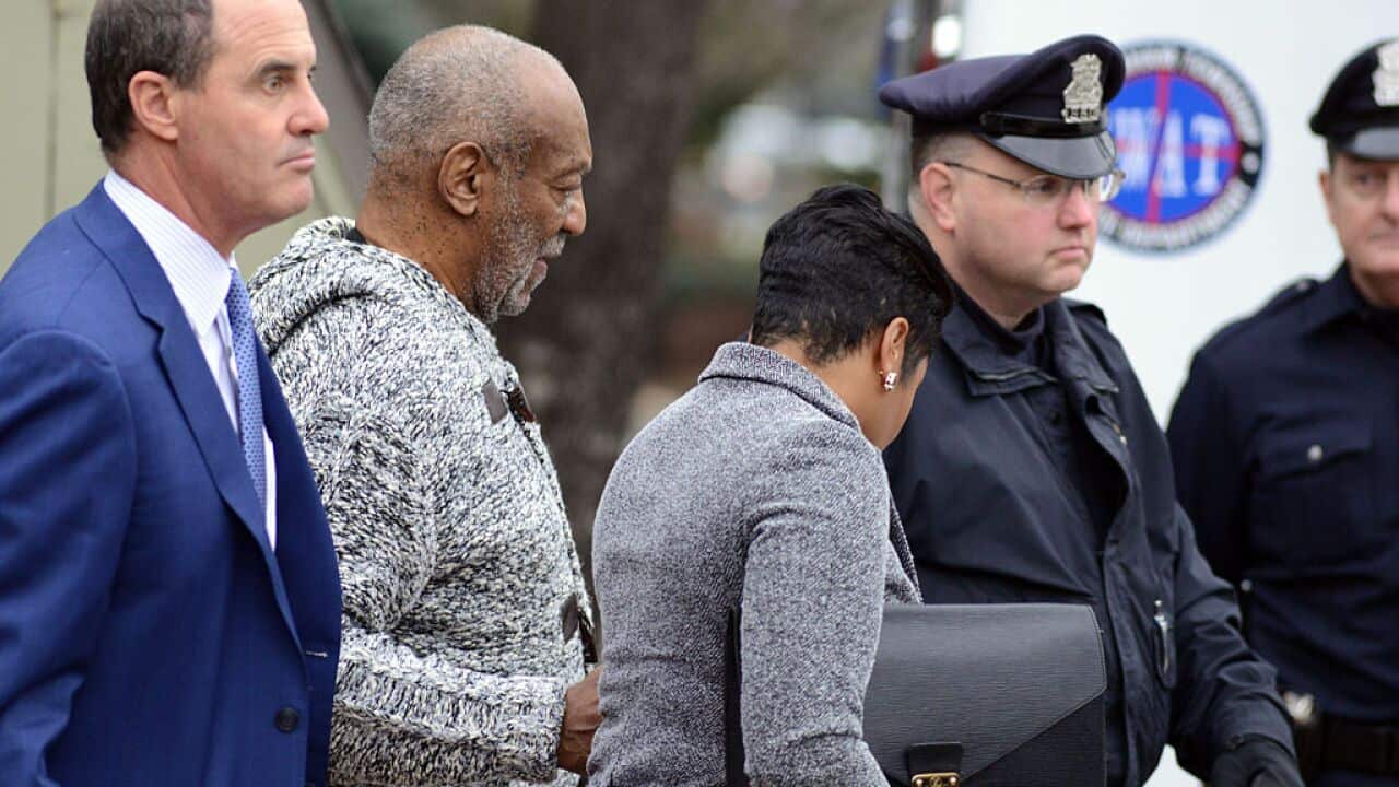 Bill Cosby is led from the Cheltenham Police Station after his arraignment at Montgomery County District Court on sexual assault charges