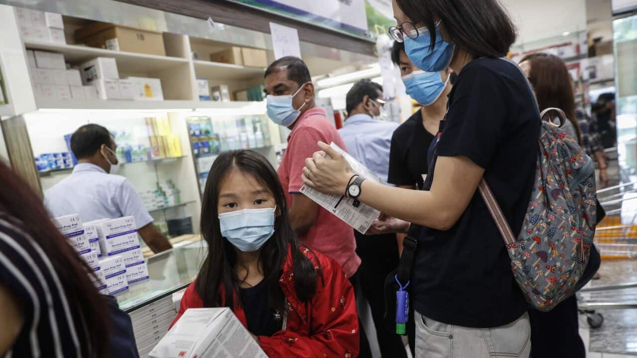 A young girl holds a box of N95 masks at a shopping mall in Singapore.