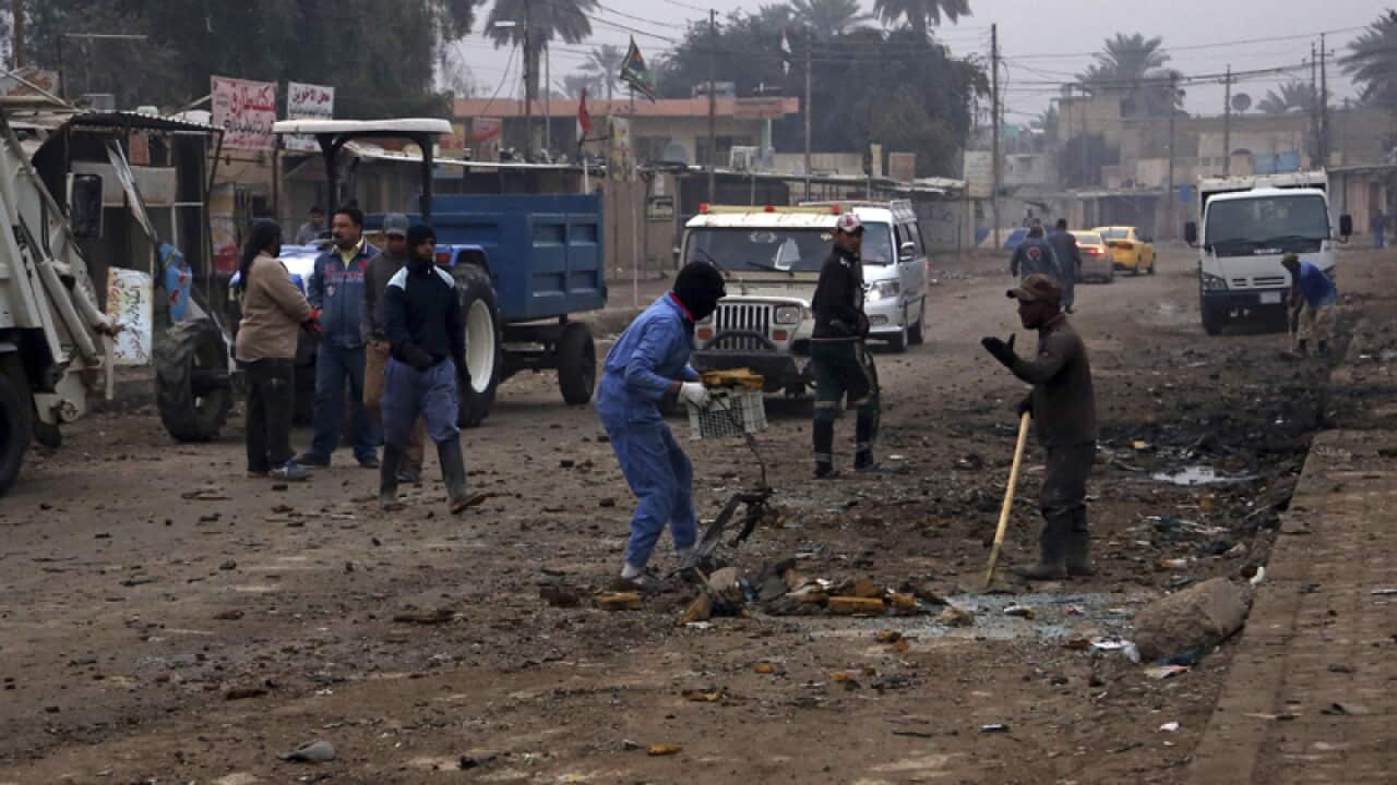 Municipality workers clean up debris in the aftermath of a car bomb