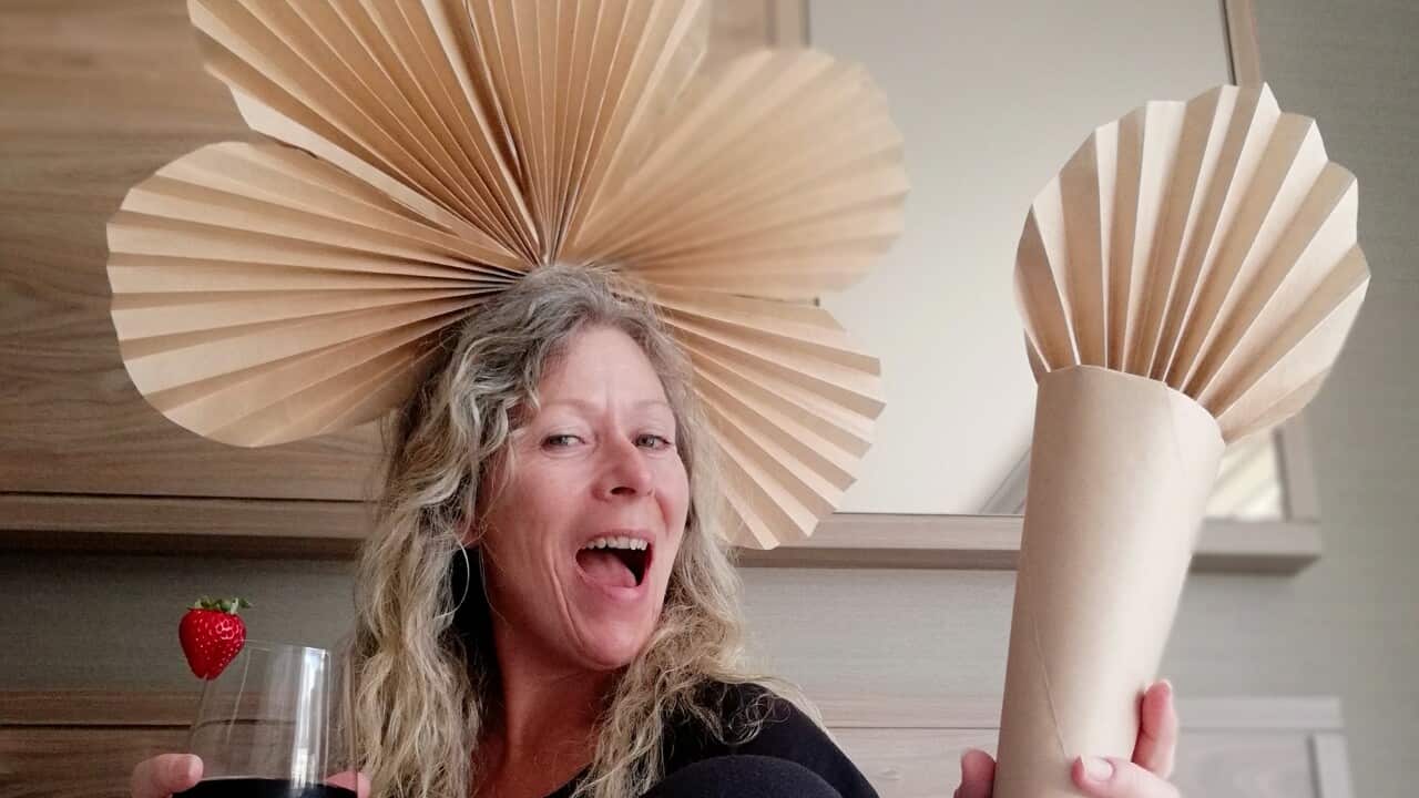 Monique Mach in hotel quarantine, wearing one of her paper bag creations