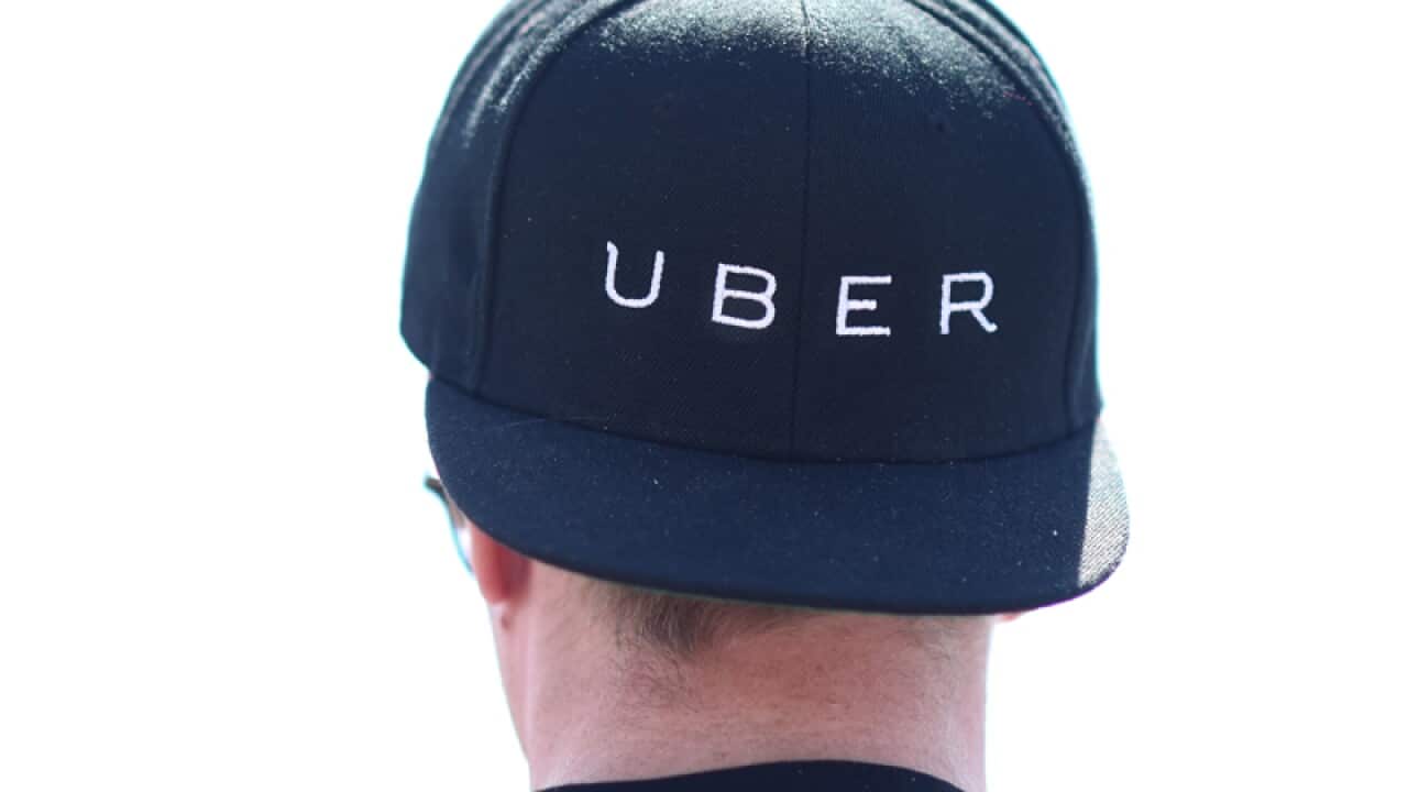 A person wears an Uber cap