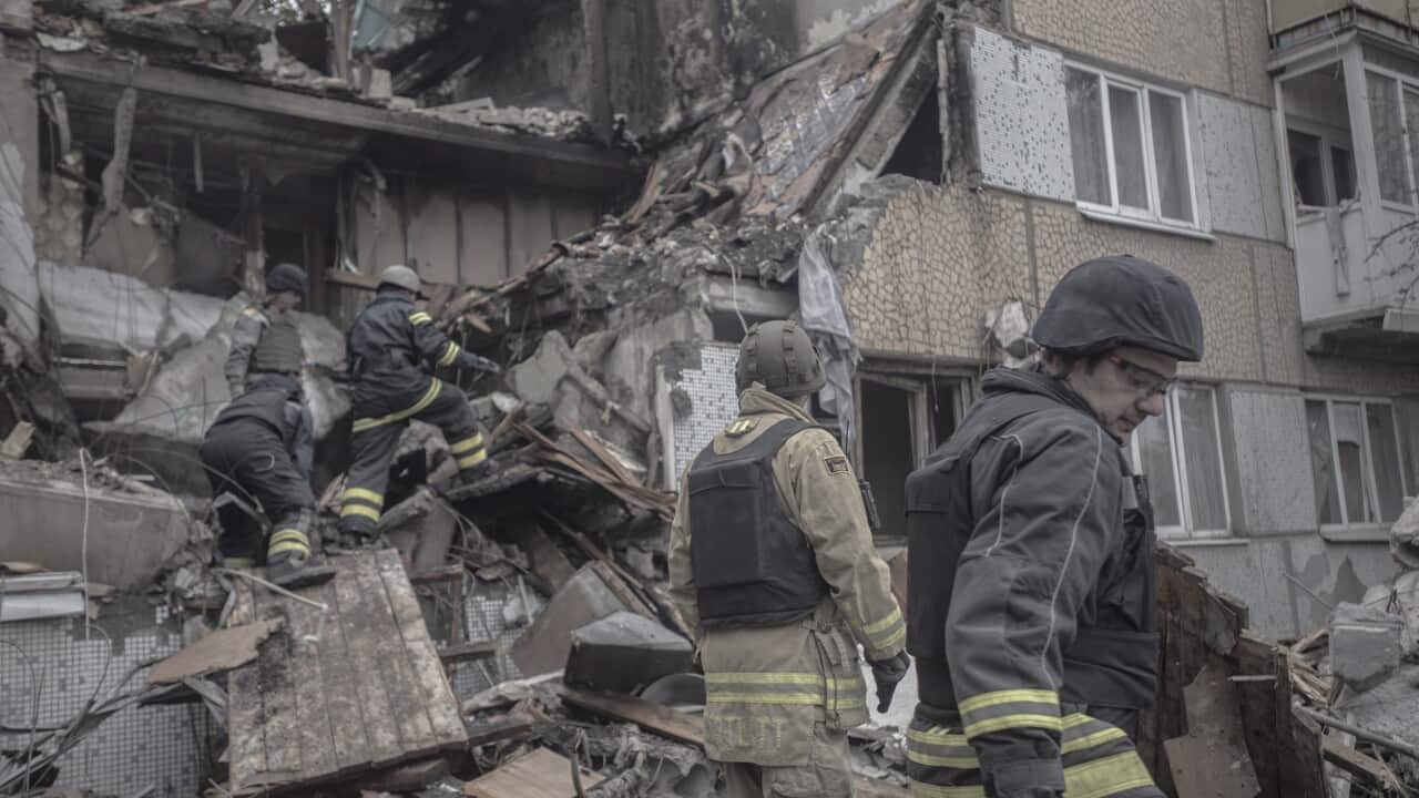 Emergency workers investigating a destroyed building.