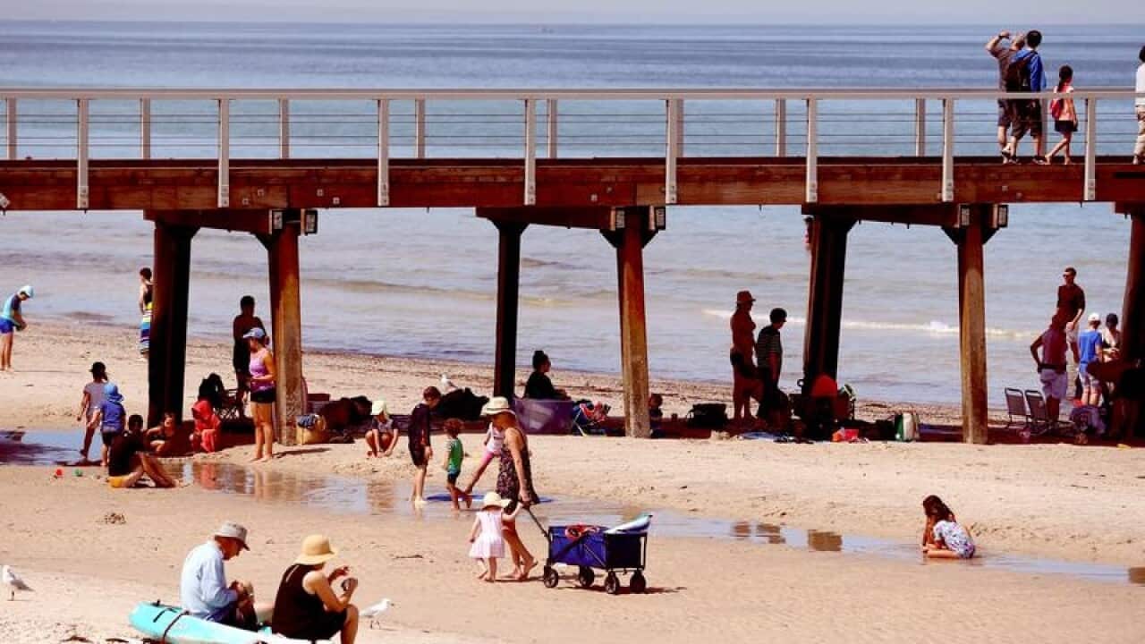 Beachgoers at Henley Beach in Adelaide seek relief from the heatwave.