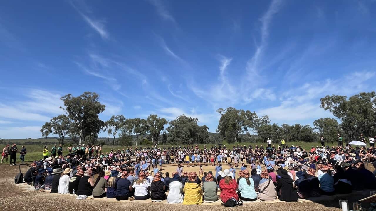 Hundreds gathered for the memorial sit in concentric circles.