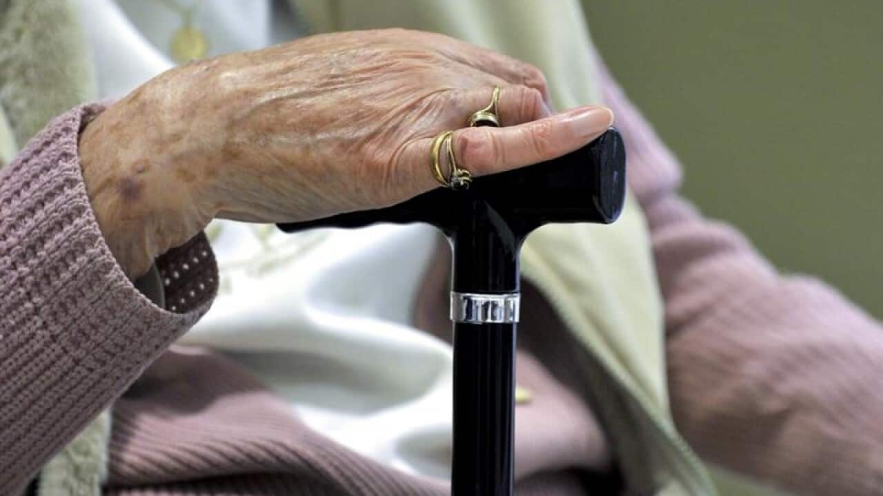 A woman uses a walking stick