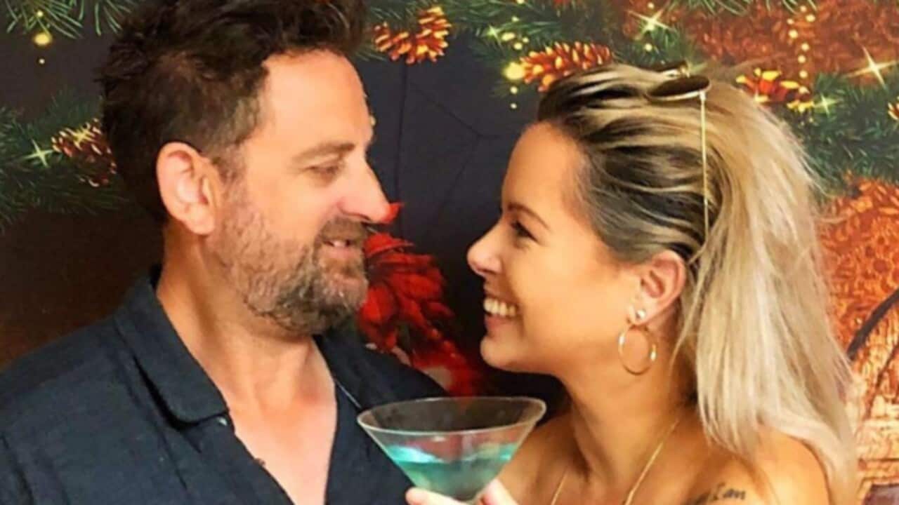 A man and a woman look at each other and smile.