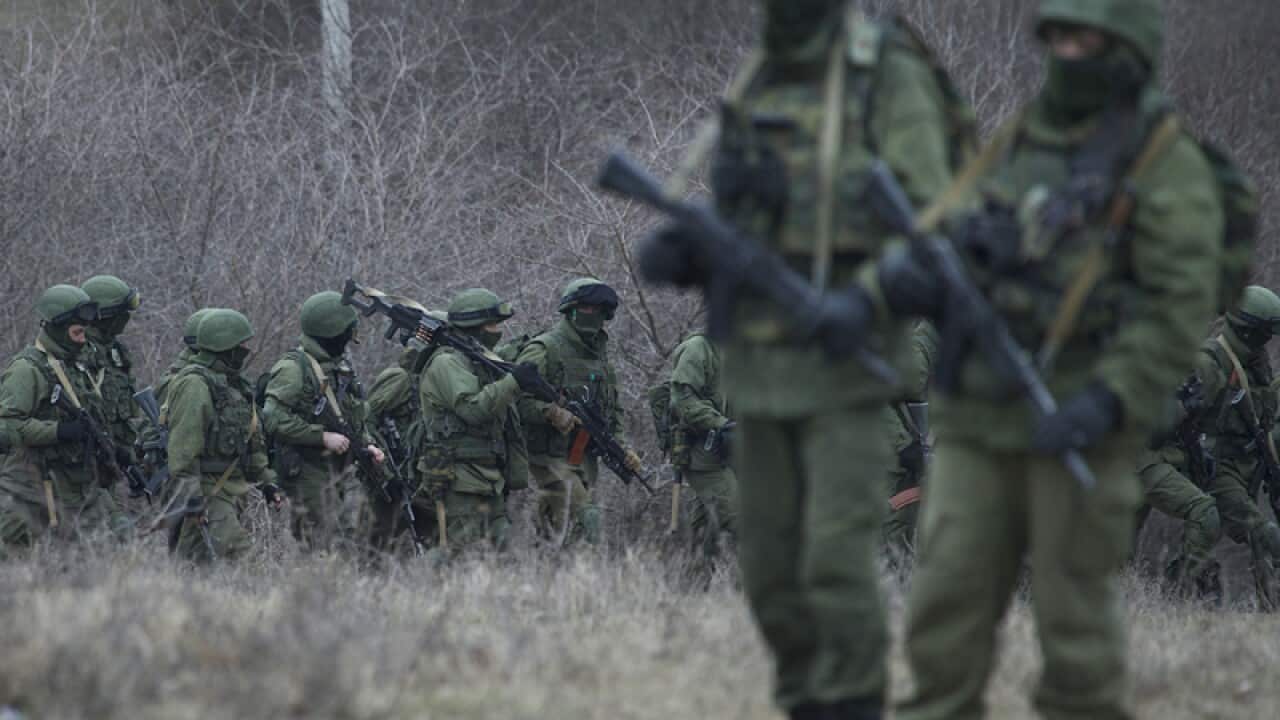 Russian soldiers walk near a Ukrainian Military Base.