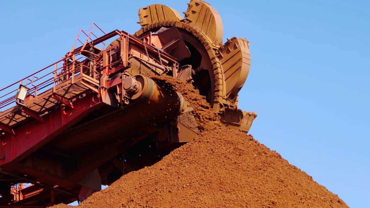 A belt conveyor piles up imported iron ore