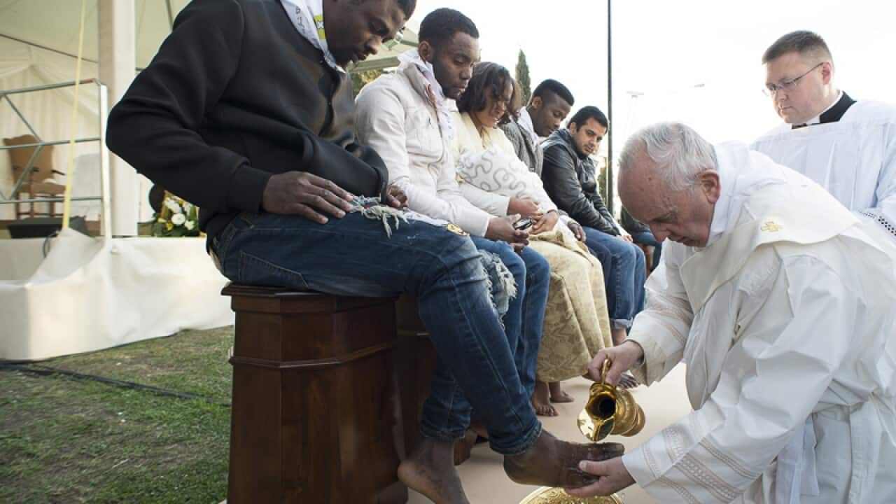 Pope Francis washes the foot of a man