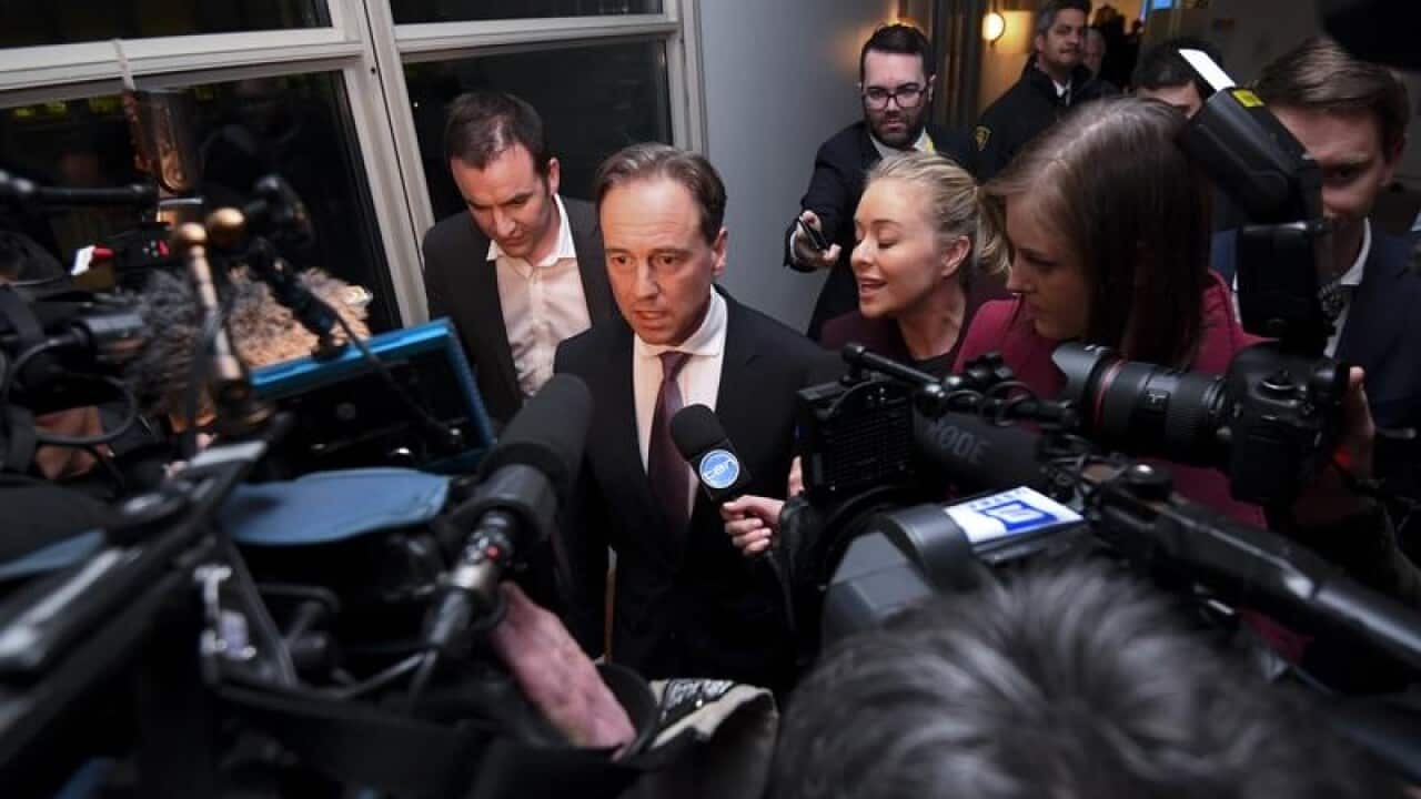 Minister for Health Greg Hunt (C) speaks to the media