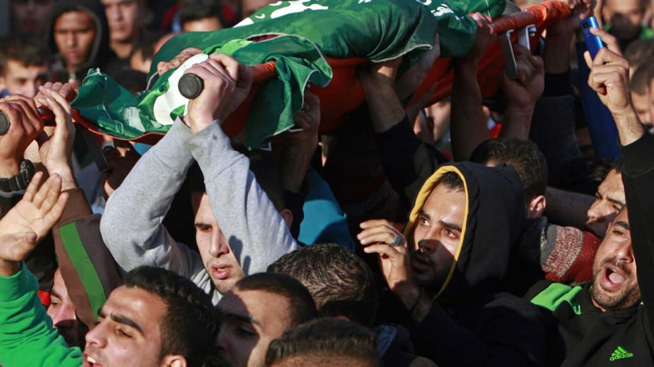 Palestinians carry the body of a man who was killed by Israeli troops