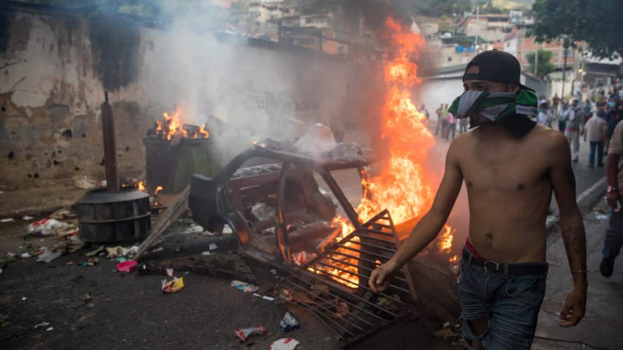 People demonstrate in the vicinity of a members of the Bolivarian National Guard command, in Caracas, Venezuela, 21 January 2019 (AAP)