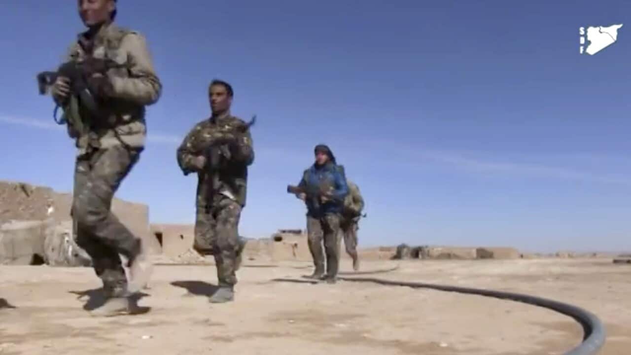 Fighters from the SDF running during fighting with IS militants, in Raqqa's eastern countryside, Syria.