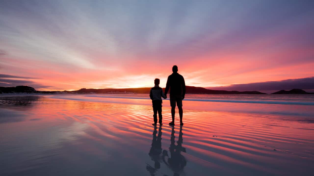 Silhouette of a father and son holding hands on beach at sunset, Western Australia, Australia