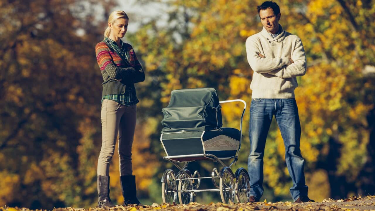 A couple looks at a baby stroller