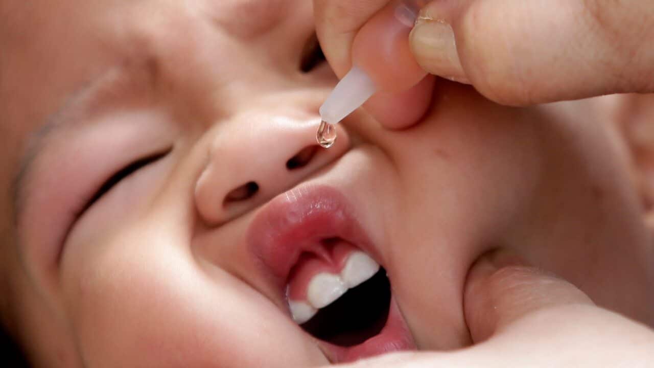 Health worker delivers a vaccine to a baby, east of Manila