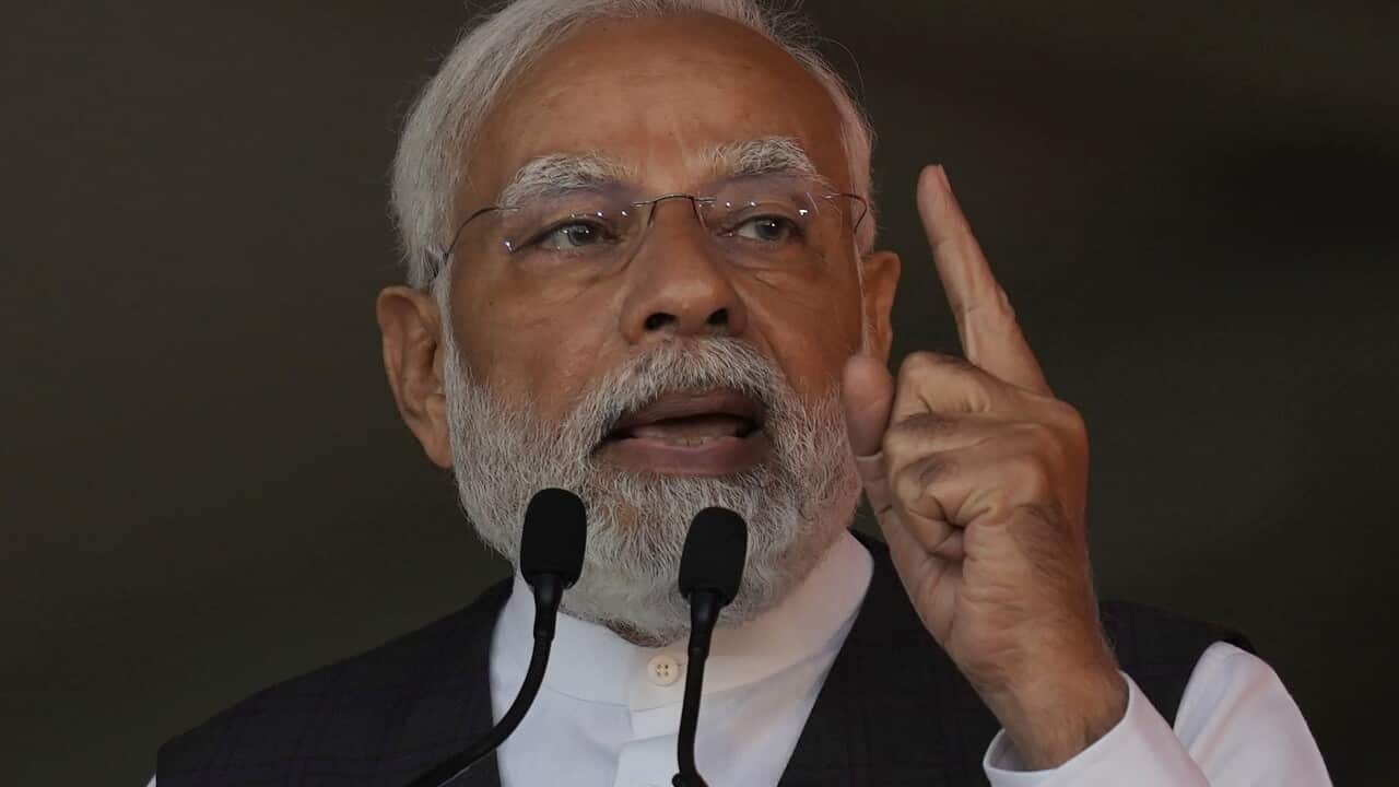 A man standing at a lectern speaking in front of a microphone.