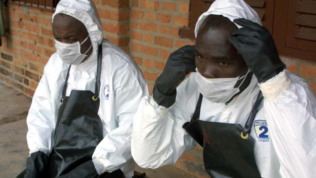 Health department members wear special equipment to treat a patient