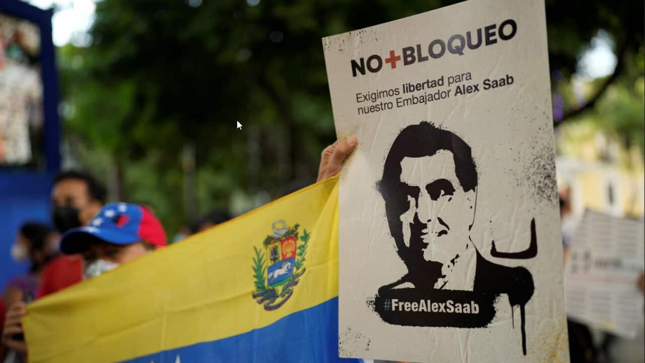 A woman holds a sign with the image of businessman Alex Saab who has been extradited to the U.S., during a demonstration demanding his release in Caracas.