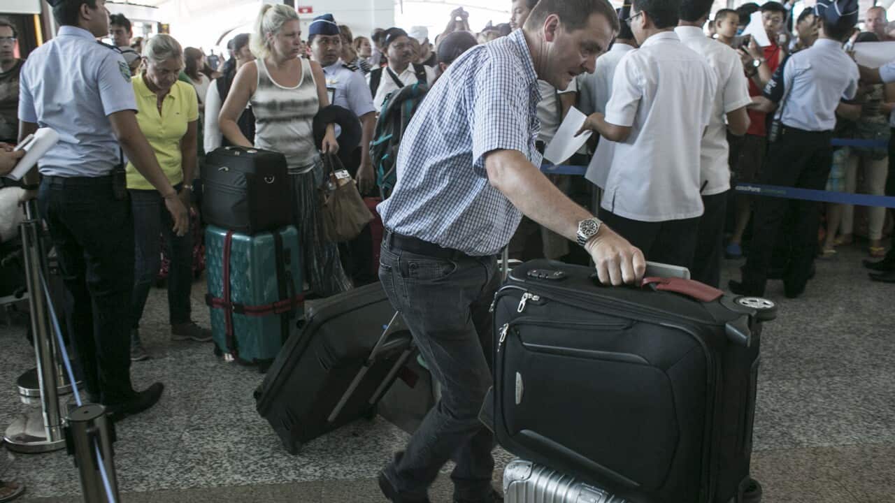 Passengers react to the re-opening of the Ngurah Rai International Airport in Denpasar, Bali, Indonesia