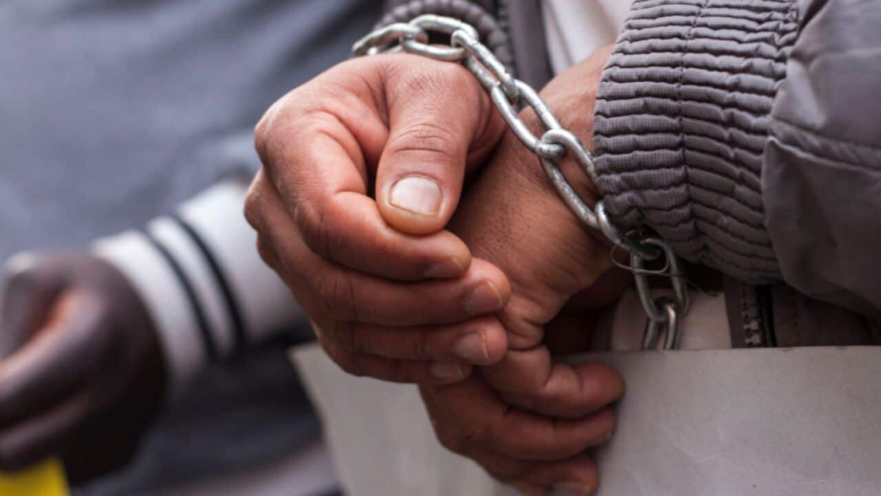 A demonstrator has chained his hands in protest.