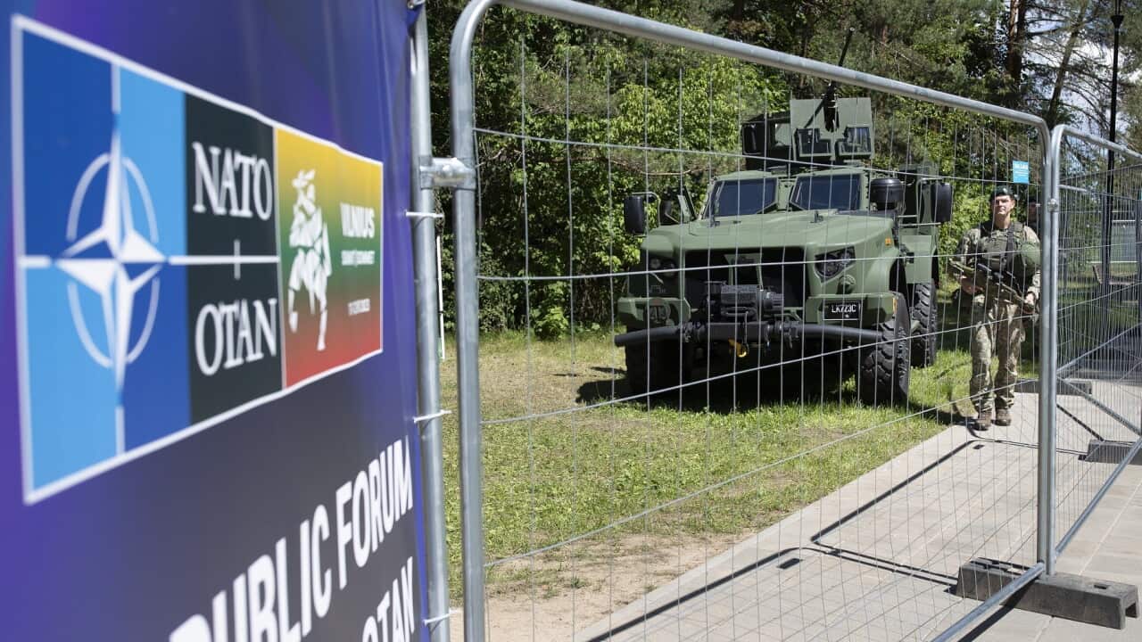 thumbnail_Soldiers stand guard at a fence surrounding the venue of the NATO summit in Vilnius, Lithuania (AAP).jpg