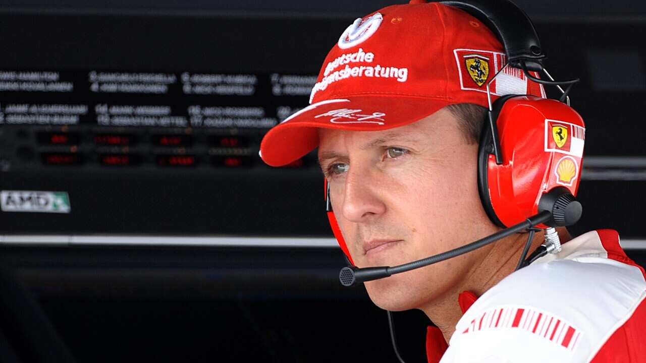 Michael Schumacher wearing a headset and a red cap