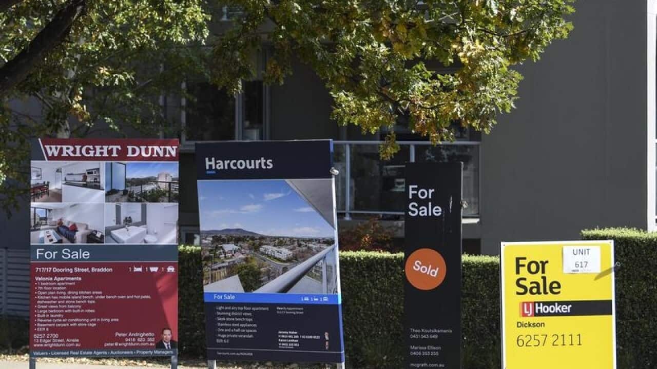 For sale signs in front of an apartment block