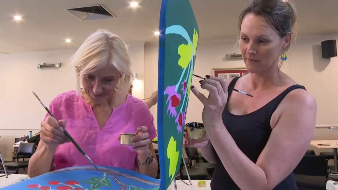 Displaced Ukrainian woman Nataliia and friend painting chairs at Kozba cafe (Supplied).jpg