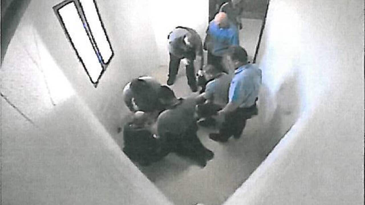 Guards surround a child in a Townsville detention centre in Queensland.