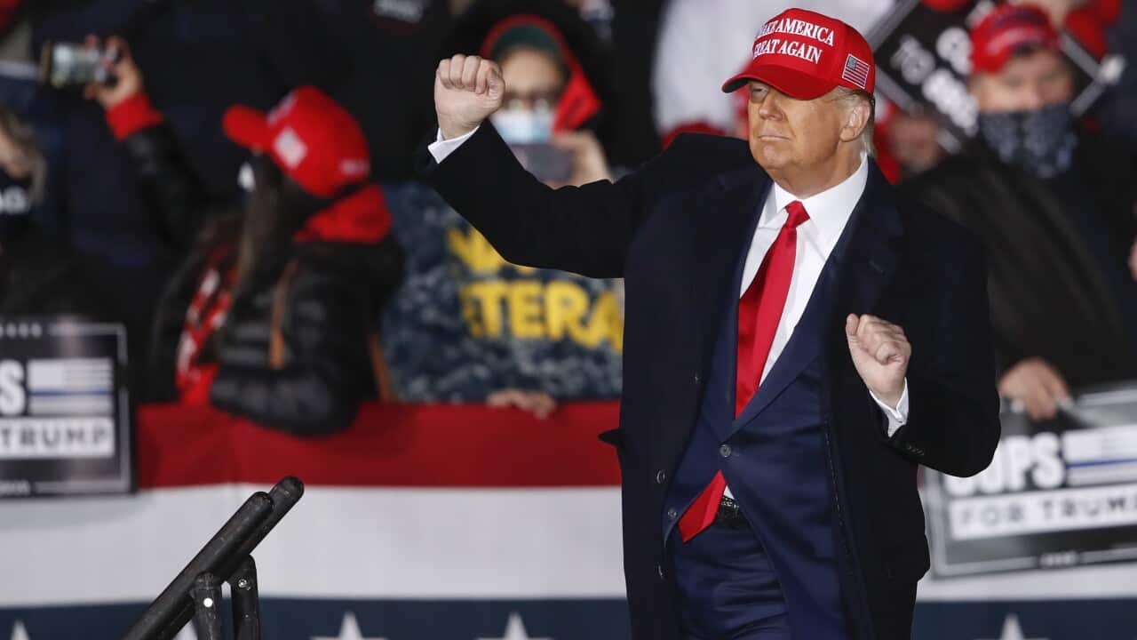 US President Donald Trump dances on stage after speaking at a campaign rally at the Southern Wisconsin Regional Airport in Janesville.