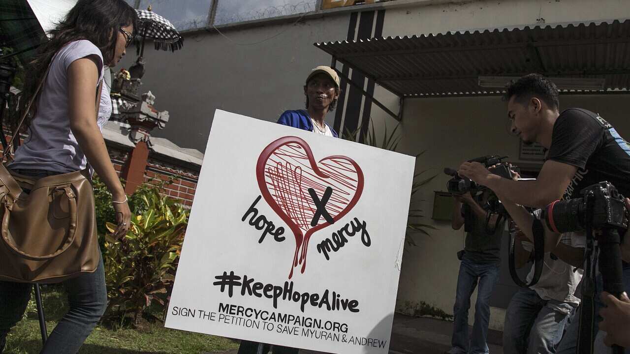 Keyenk and other former prisoners bring a painting rejecting the execution of the Bali Nine ringleaders to Kerobokan Prison in Bali.