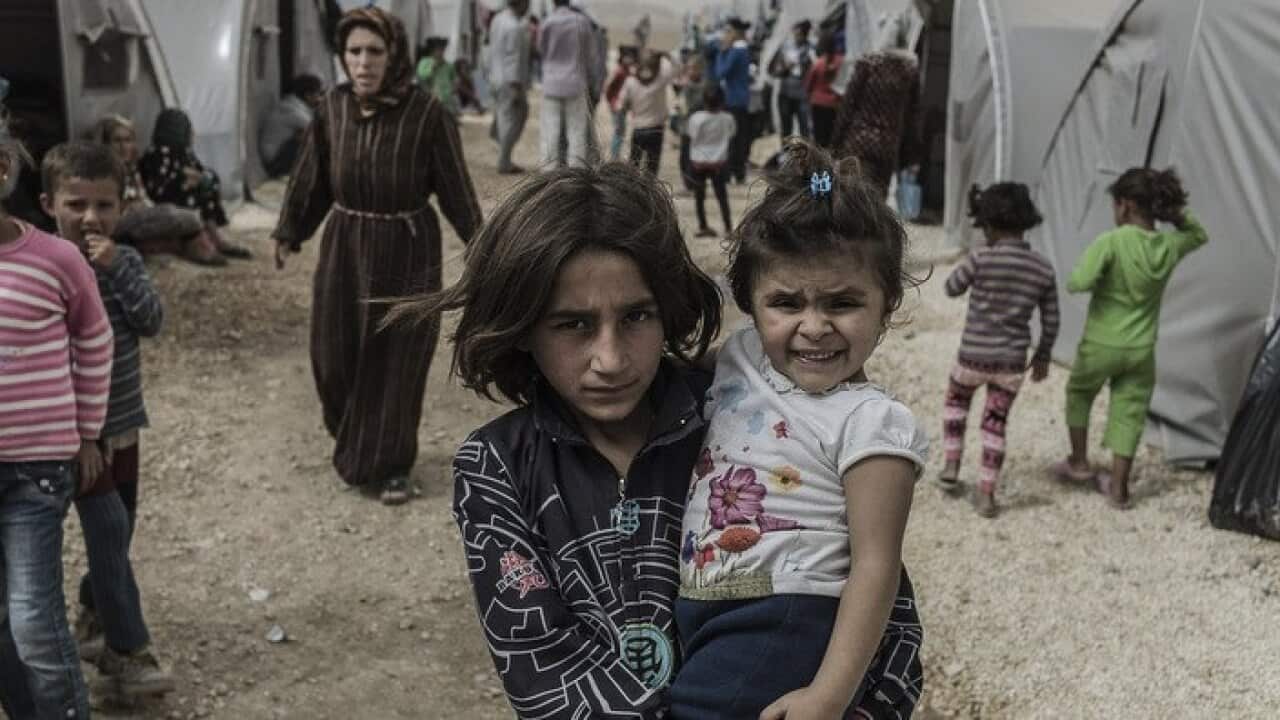 Children pose at a refugee camp near Suruc in south-eastern Turkey