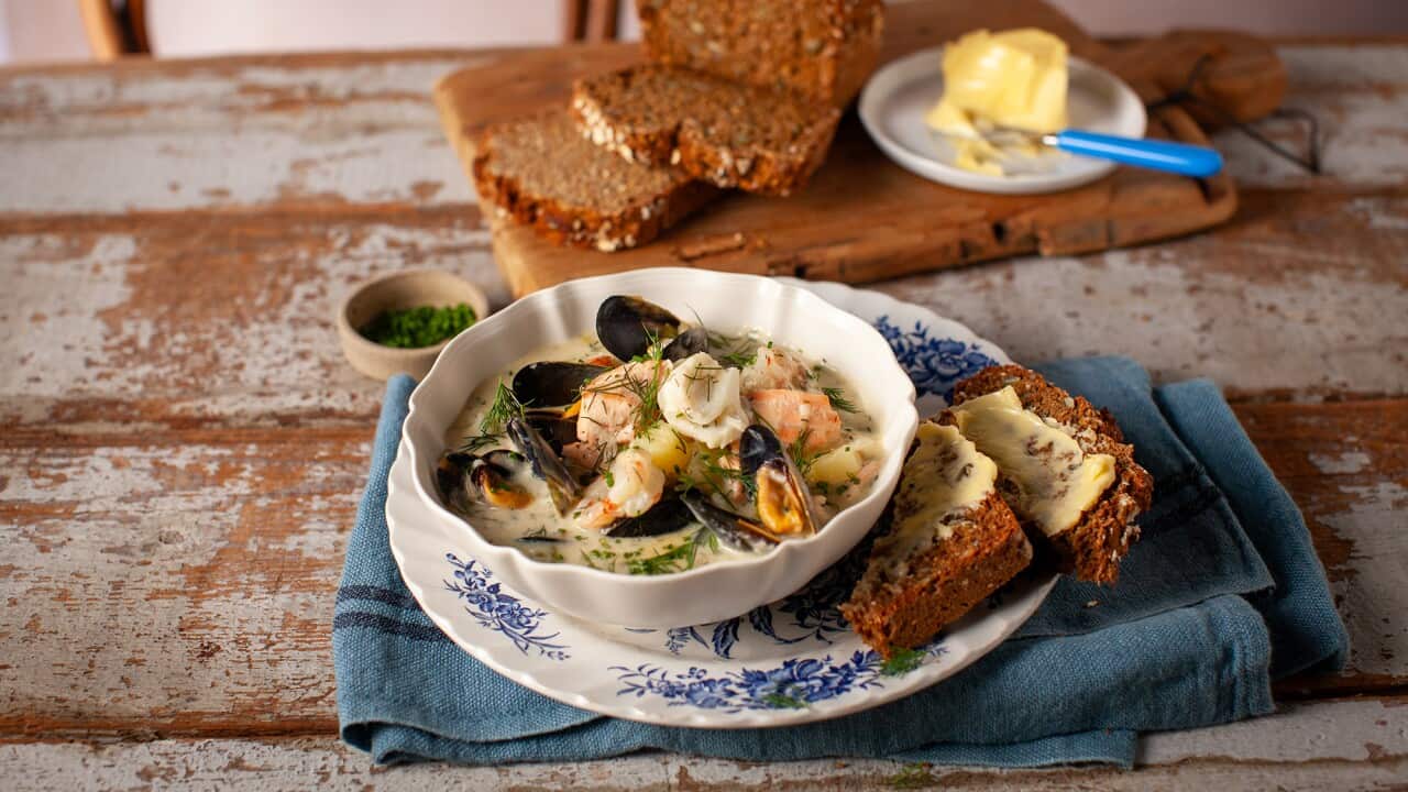 Seafood chowder in a bowl, with buttered brown soda bread.