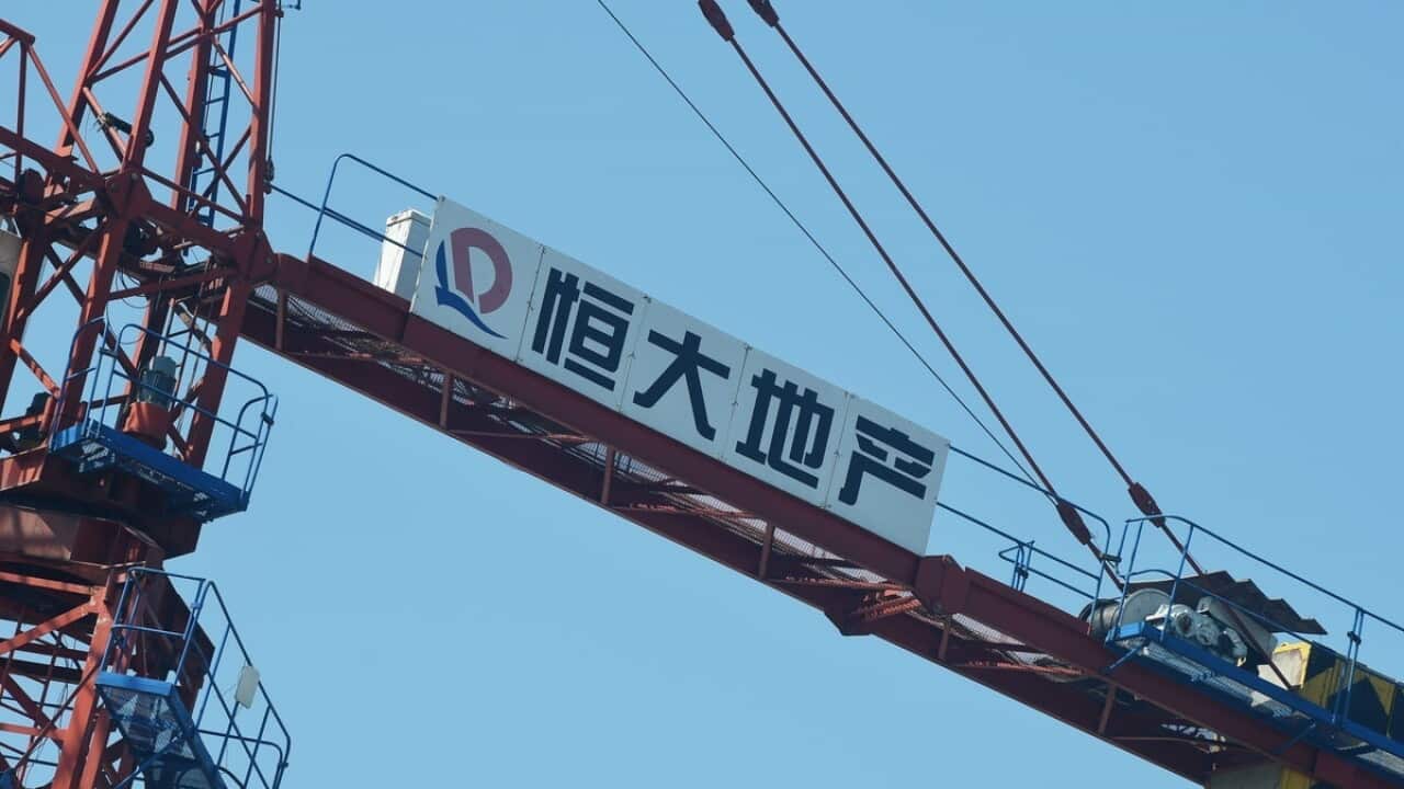 Crane - The Evergrande logo at a construction site.