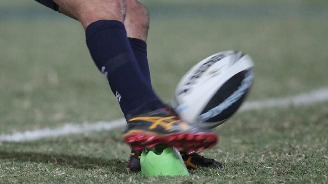 A football is kicked during an NRL match