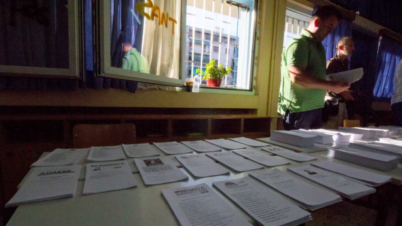 Ballot papers are seen on a desk inside a voting station.