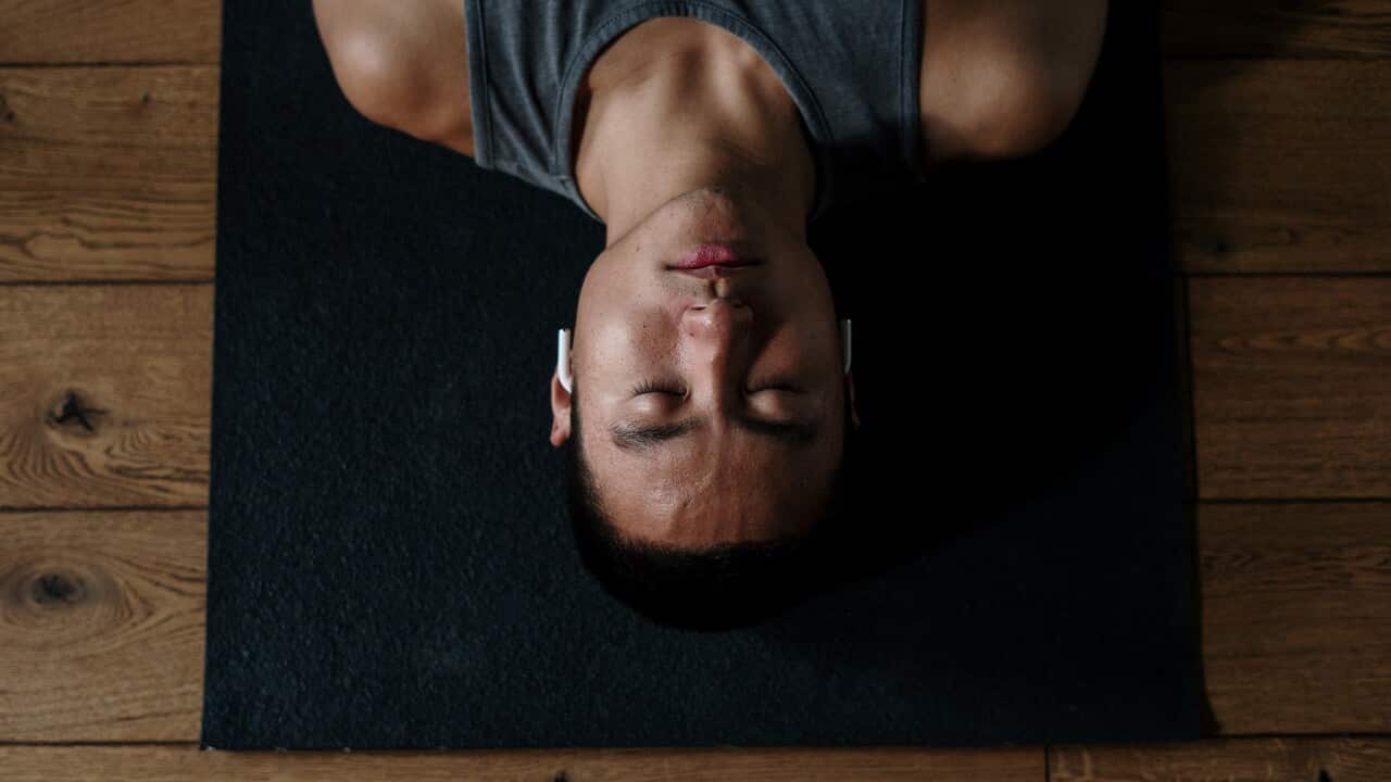 Man lying down with eyes closed, meditating