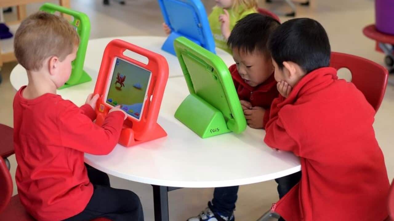 Children play on iPads in an early learning school in Canberra