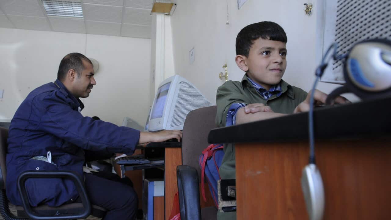 Patrons use computers in an internet café.