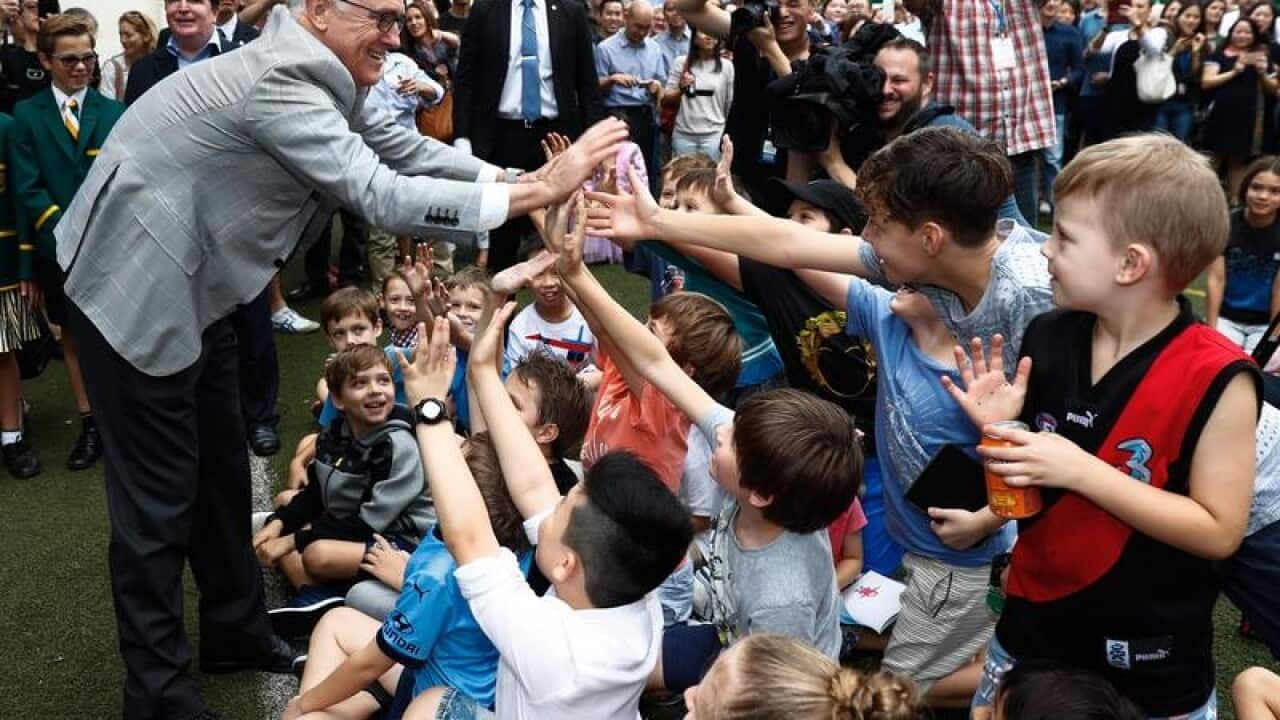 Prime Minister Malcolm Turnbull gives high-fives to children