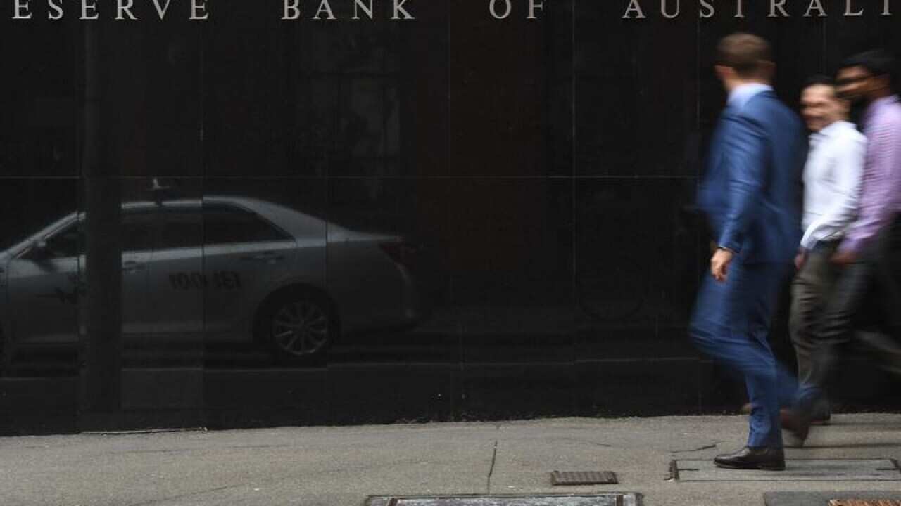 Pedestrians walk past the Reserve Bank of Australia