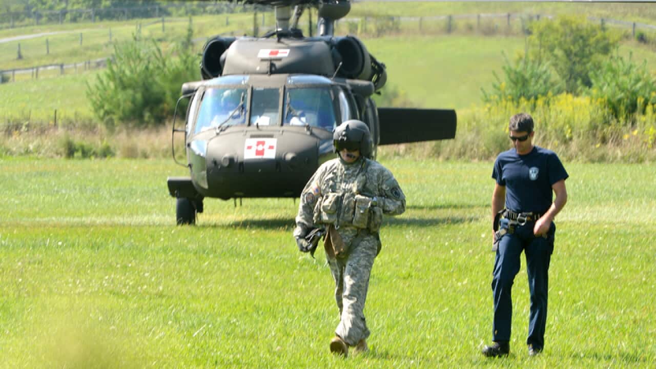 Two men walk away from a helicopter during a search and rescue mission