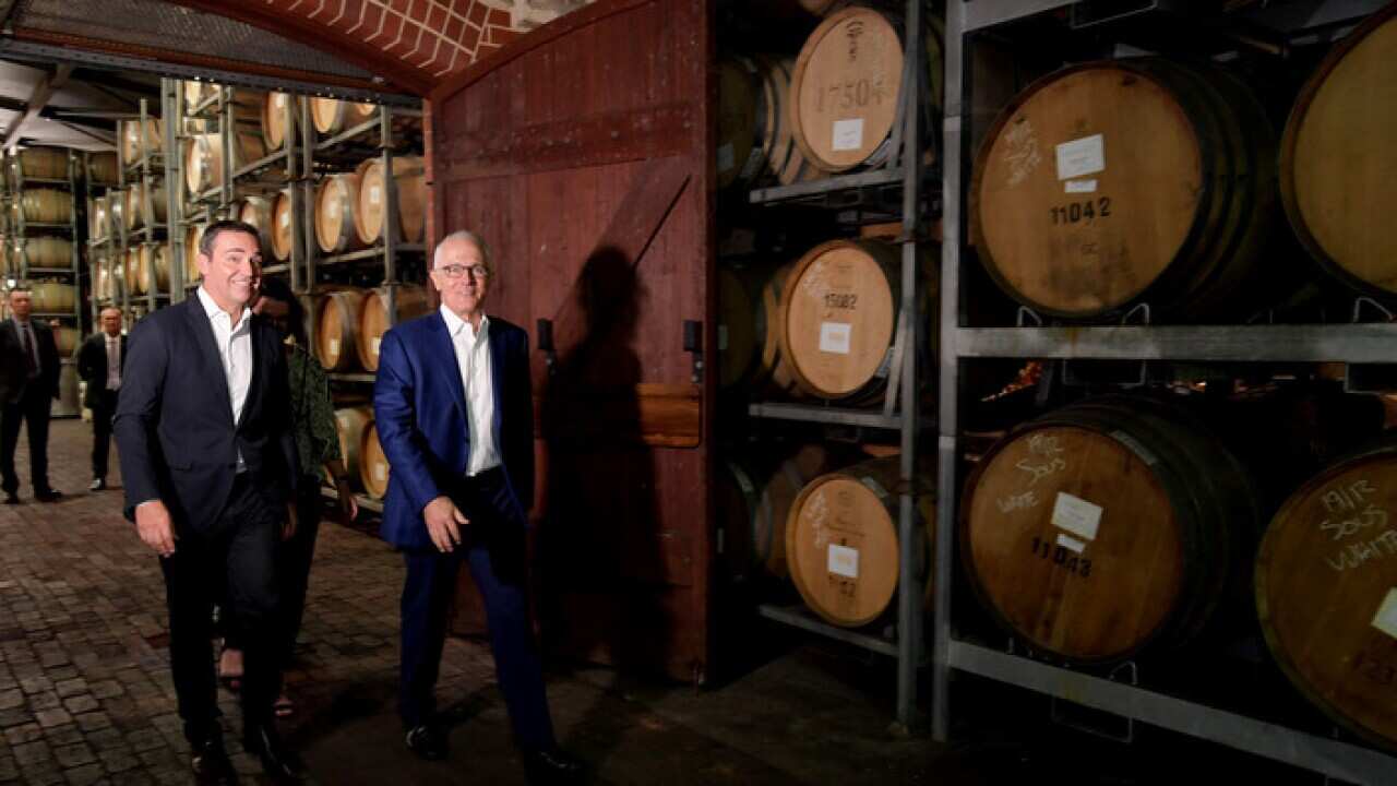 South Australian Liberal leader Steven Marshall (left) with Australian Prime Minister Malcolm Turnbull walk past wine barrels